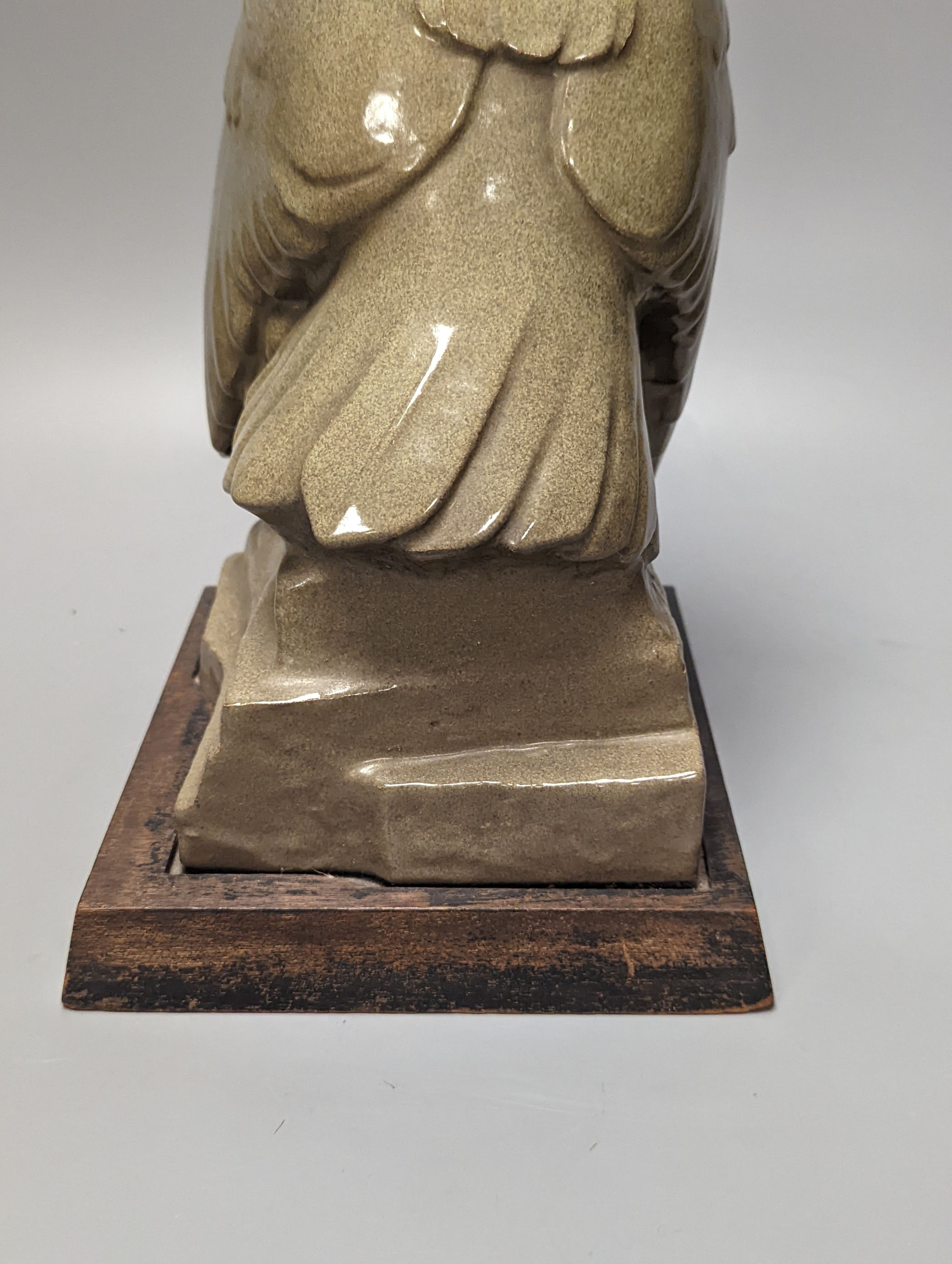 A glazed pottery owl model, 30cm, on wood plinth